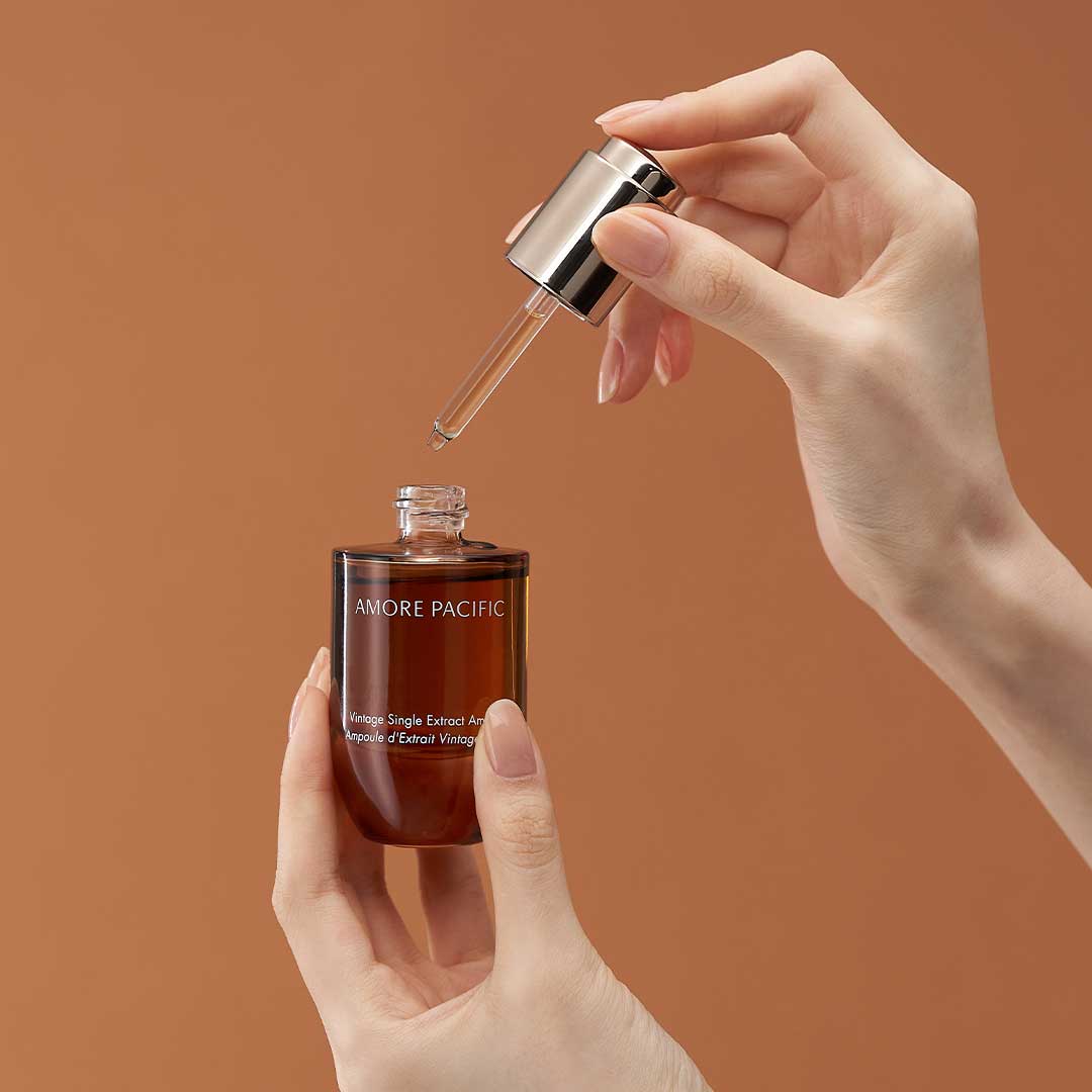 Model holding Vintage Single Extract Ampoule skincare product