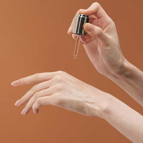 Model dispensing skincare product on top of hand