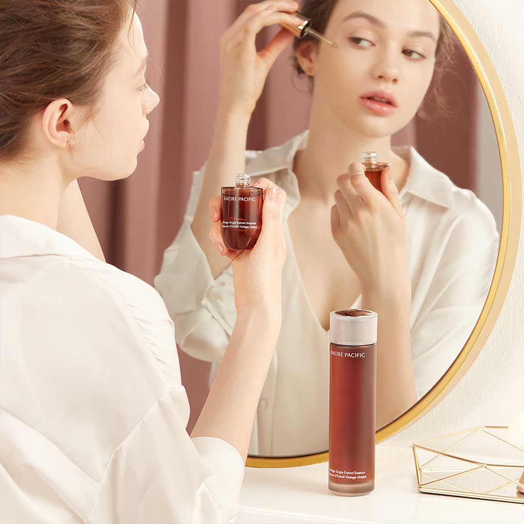 Model using skincare products in mirror